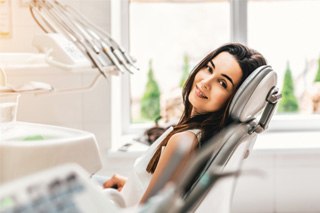 Woman sitting in dental chair and smiling