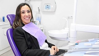 Happy dental patient sitting upright in treatment chair