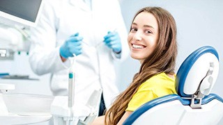 Smiling dental receptionist talking with patient