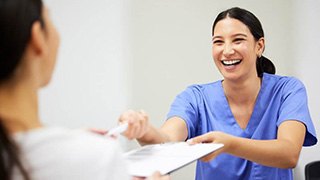 Smiling young woman in dental treatment chair, looking over her shoulder